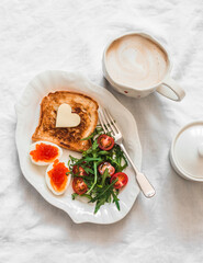 Delicious breakfast, brunch - toasts with butter, boiled eggs with red caviar, fresh salad and coffee on a light background, top view