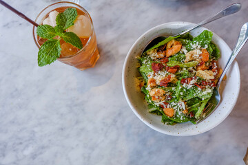 Top of Caesar salad with glass of ice lychee tea on table in copy space and healthy food concept.
