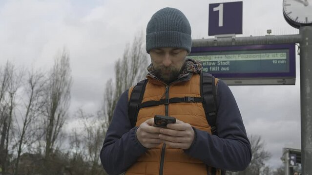 Train cancelations in Germany. Man waiting for long delayed commuter train at suburban railroad station in Berlin, Germany. Zug fallt aus, Deutschland. Railroad delays in Germany. Urban life citizen. 