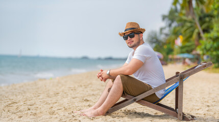 Asian man sitting chair beach inside sea,Relax time at summer