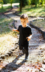 Little boy walks in the park in black clothes
