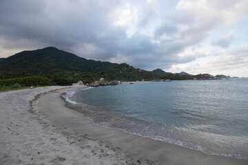 Beautiful blue cloudy sunset with jungle mountains and calm blue caribbean into colombian tayrona national park