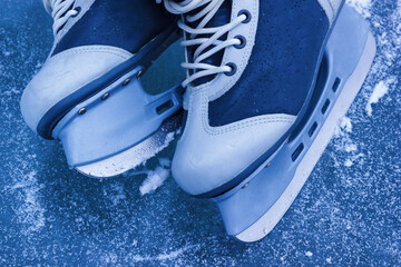 The ice skating shoes for winter sport. Pair of ice skates on frozen rink, closeup view.