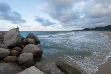Fototapeta na wymiar Beautiful shore big rocks with blue caribbean sea in blue dawn beach landscape