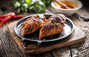 Marinated grilled chicken breast in BBQ sauce and served on a cast iron pan - Close up