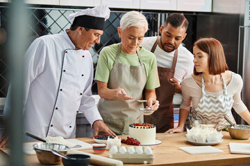 mature woman decorating cake next to her cheerful interracial friends and chef, cooking courses