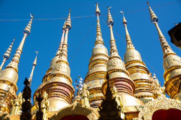 group of small golden pagoda in Wat Phra That Suthon Mongkhon Khiri, Phrae province, northern of Thailand.