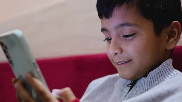 dangerous colorful light on young kid face watching mobile and playing online game at home at night