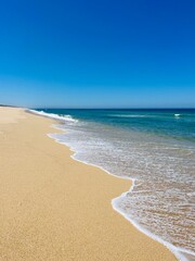 Fototapeta na wymiar Blue seascape, sandy sea coastline, empty wild beach, pure blue sky, sea horizon