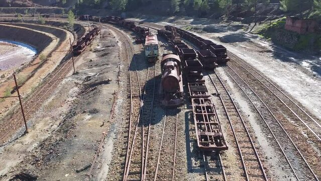 Aerial drone view of an old and rusty steam mining train used for transportation of the copper of  Corta Atalaya mining exploitation. Remains of the old copper mining operation in Minas de Riotinto