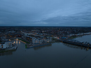 Fototapeta premium Aerial overview at dusk of the city of Zutphen, along the river Ijssel in Gelderland, The Netherlands. Birds eye aerial drone view in the Dutch province of Gelderland.