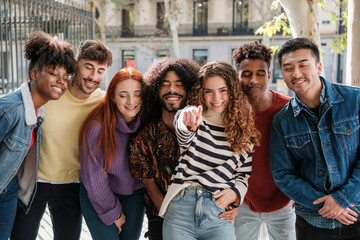 Young people together pointing the way while their companions close their eyes. Concept: Choice, trust