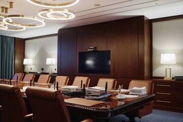 Interior of spacious boardroom for business meetings with wooden furniture and leather armchairs