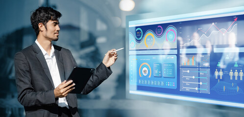 Businessman holding digital tablet with business infographic data and analytics data dashboard.