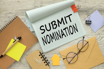 SUBMIT NOMINATION stationery and calculator on financial chart. text on notepad page with spiral