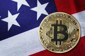 Close up gold bitcoin coin on usa flag