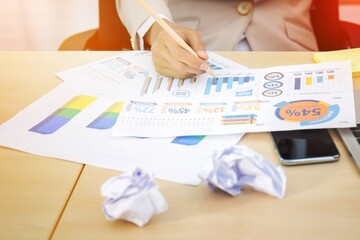 Close-up image of business executive analyzing diagram in financial report with sales data