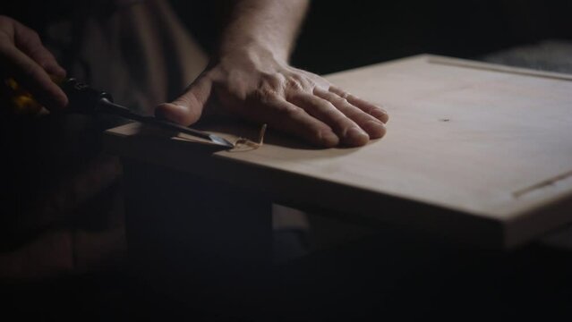 close up of hands chiselling and wood working