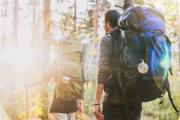 Forest camping adventure in travel hiking outdoors. Trip tracking in mountains. People adventurers explorers with backpacks walking in woods together