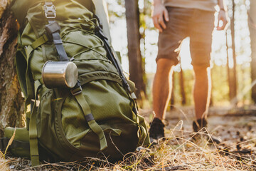 Caucasian male traveler standing near backpack while traveling in forest. Travelling concept. Trip...
