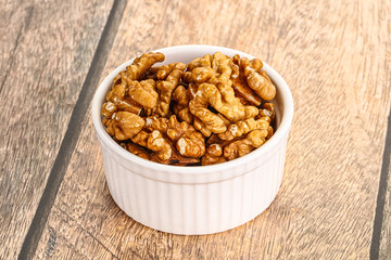Cracked unshelled walnut in the bowl
