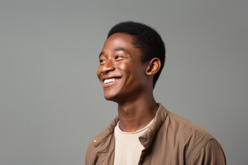 Fototapeta premium A man wearing a tan jacket smiles, radiating warmth and contentment.