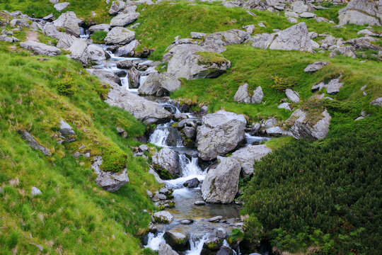 rapid balea water stream among stones and boulders on the hills of fagaras ridge. beautiful scenery in romanian mountains. view from above