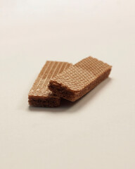 Wafers with chocolate flavored cream on a white and wooden background. Wafer With Chocolate Drizzle. A set of delicious crispy sweet wafers of different shapes. long, square, tasty and crunchy cake.