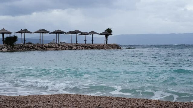 Powerful waves crashing the coast of Njivice, Croatia one day after Storm Ciar&aacute;n smashed into Krk Island. Birds flying slowly above the disquiet sea surface. Cinematic seascape, turquoise wavy water.