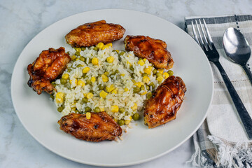 chicken wings  with rice corn and peas