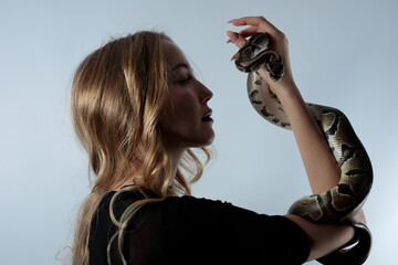 Snake python shooting on blond young woman with light effekts