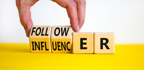 Follower or influencer symbol. Concept words Follower Influencer on wooden cubes. Beautiful yellow table white background. Businessman hand. Business follower influencer concept. Copy space.