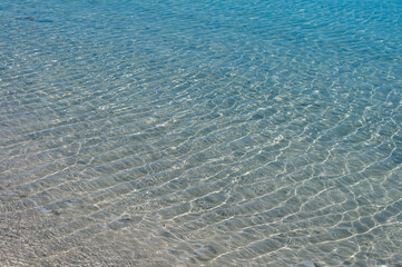 Clear water reflections on shallow sandy beach bottom. UAE Jumeirah beach.