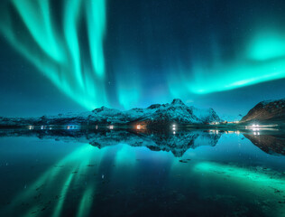 Northern lights, snowy mountains, reflection in water at night