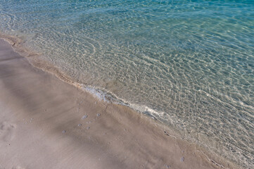 Clear water reflections on shallow sandy beach bottom. UAE Jumeirah beach.