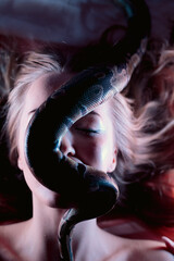 Snake python shooting on blond young woman with light effekts