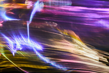 Long exposure photo of vibrant colours on a black background. Multicolored dynamic Light painting. Soft rainbow light flares overlay. Abstract art.