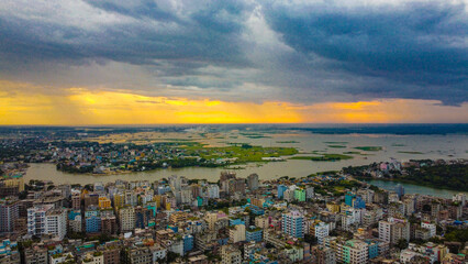 Aerial urban Sunset in a dense city by the water . Dhaka is the capital of Bangladesh and one of the most populated city in the World.