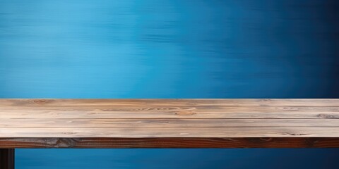 Wooden table with blue background for product placement or montage.