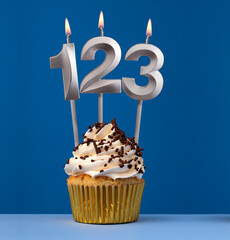 Vertical birthday card with cupcake - Lit candle number 123 on blue background