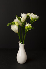 Nice bouquet of white freesia flowers in vase on table