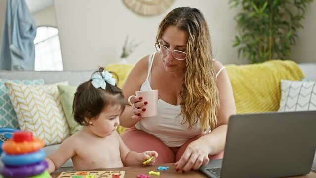Family love in play, mum and daughter bonding over maths game on sofa, enriching maternity amid teleworking lifestyle.
