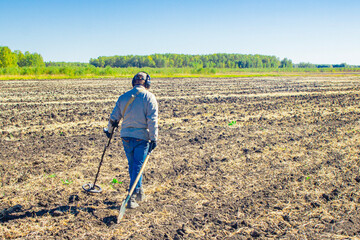 Metal search. A man holds a metal detector in his hand. Search for treasures. Search for antique coins.