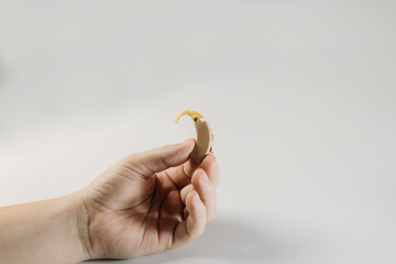 hearing aid on white background in hand, cochlear implant