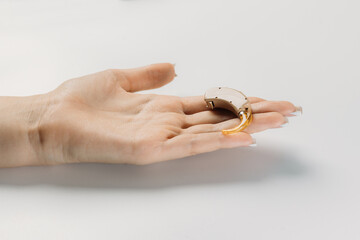 hearing aid on white background in hand, cochlear implant