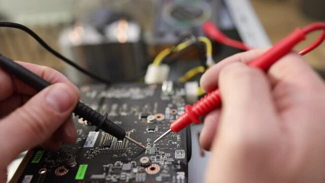 Close-up image of technician man hand measuring electrical voltage of computer mainboard by using digital multimeter. Maintenance and repair computer hardware service concept.