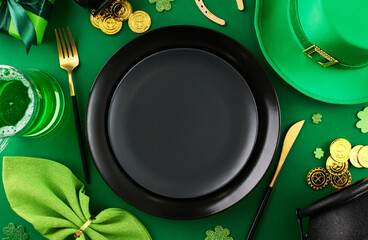 Clover brilliance: Celebratory setup for St. Patrick's Day. Top view photo of plates, cutlery, leprechaun hat, green beer, festive decor on green background