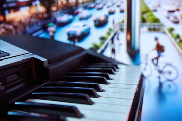 Close-up of piano keyboard with blurred street with cyclist on background. Ad campaign for urban...
