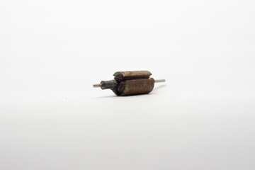Brown rust sticks to the iron of an electric motor dynamo on a white background