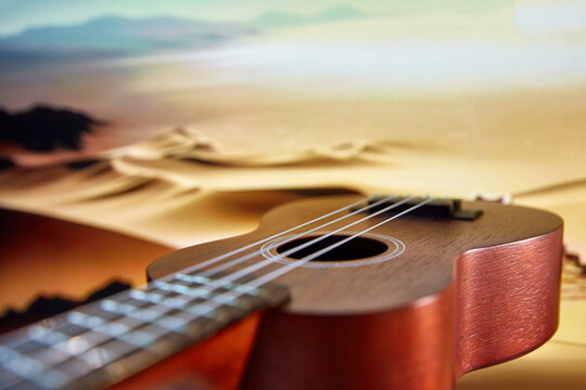 Acoustic guitar close-up with desert dunes in the background. Marketing image for a documentary about music around the world. Concept of music instruments, performance, hobby, art, entertainment